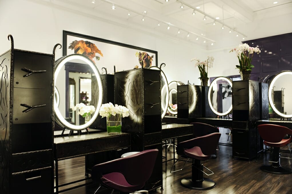 The José Eber Salon interior in Beverly Hills, featuring luxurious styling stations with illuminated mirrors, modern design, and fresh orchid arrangements. The José Eber Salon interior in Beverly Hills, featuring luxurious styling stations with illuminated mirrors, modern design, and fresh orchid arrangements.
