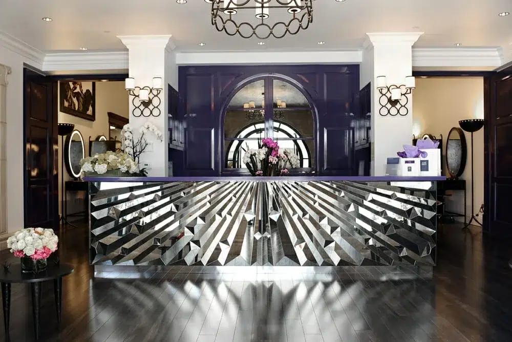 The glamorous José Eber Salon, featuring a mirrored art-deco reception desk, fresh floral arrangements, and refined modern design in Beverly Hills. The glamorous José Eber Salon, featuring a mirrored art-deco reception desk, fresh floral arrangements, and refined modern design in Beverly Hills.