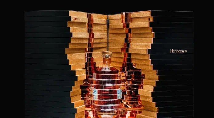 Hennessy 8: The Legacy of a Masterpiece Exquisite Hennessy 8 decanter encased in an architectural wooden and copper display, reflecting the artistry of Maison Hennessy’s master blender.