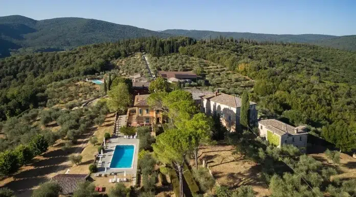 Montestigliano: Tuscany’s Hidden Estate of Timeless Elegance Aerial view of Montestigliano nestled among olive groves and cypress trees in the Tuscan countryside.