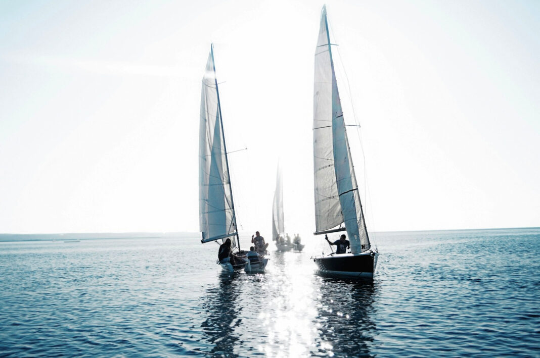 vacationers on a sailing boat in the ocean. Photo by Lazarescu Alexandra via unsplash