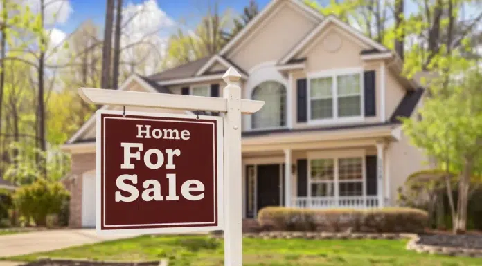 The 5 Steps You Need To Take Before You Sell Your Home A big sign in front of a home that is selling. Photo via vecteezy