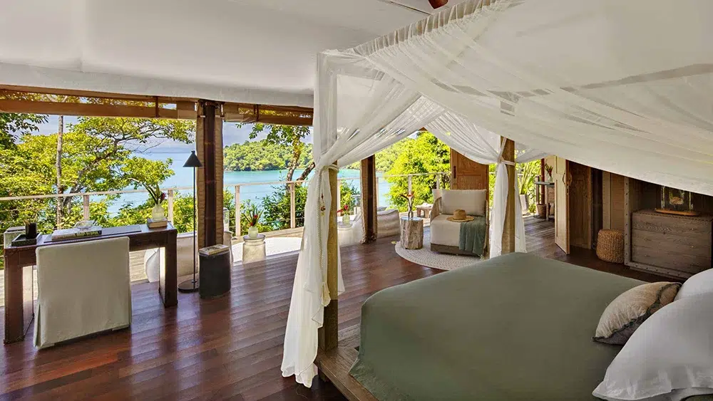 Ocean-view villa at Islas Secas, Panama, featuring open-air design, canopy bed, and panoramic sea vistas.