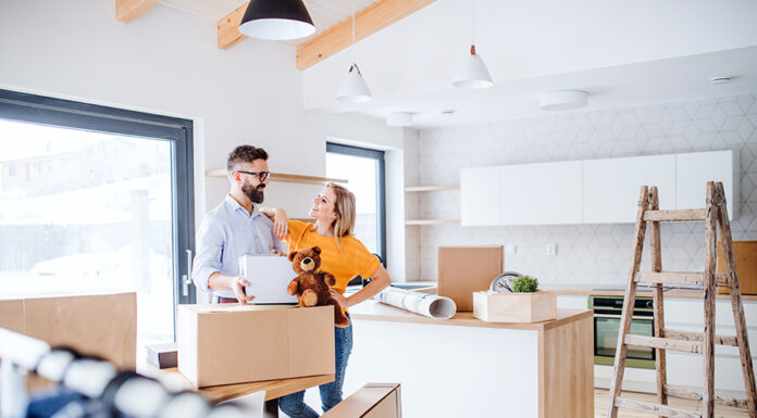 Moving Into A New Home? Things To Fix Before The Big Day A young happy couple furnishing new house, a moving in new home concept.