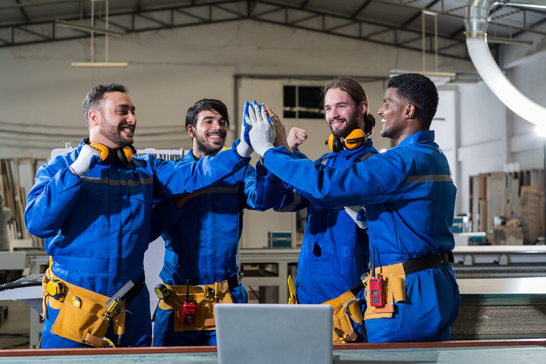 Group of male technician workers working and holding hands toget Group of male technician workers working and holding hands toget