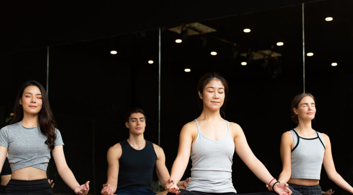 Want to Get Started With Yoga? Here’s How Yoga class of young people interested in yoga activities With a yoga teacher who helps teach yoga postures to students In order to be physically strong and flexible.