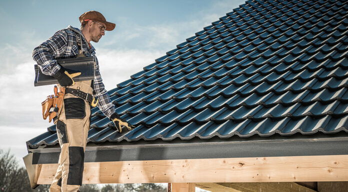 Reasons Why You Might Need to Hire a Roofing Contractor Roof inspector reviewing the work done on a house roof. Photo via free Adobe Stock photos