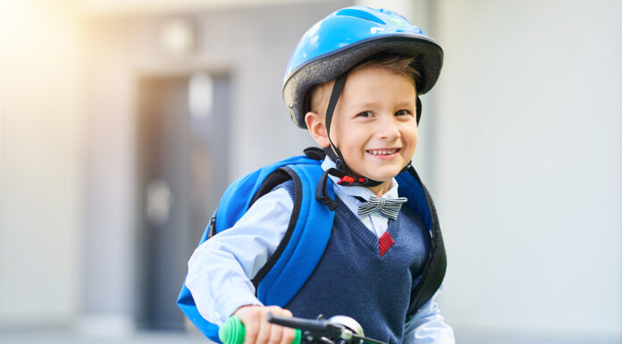 Safety Tips From The Experts For Parents To Ensure Their Family Is Safe School boy in safety helmet riding bike with backpack