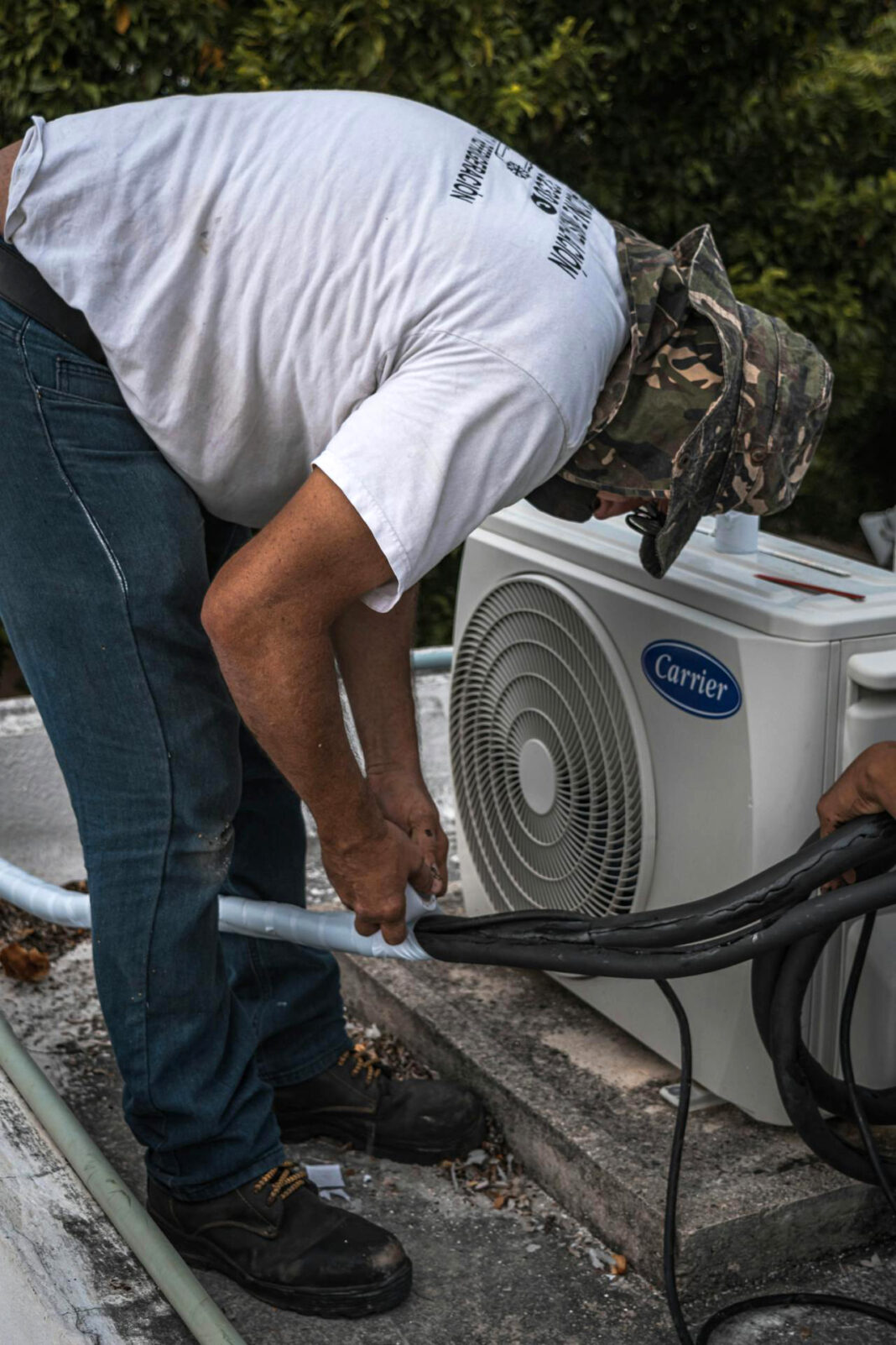 Men working on air conditioner. Photo via pexels