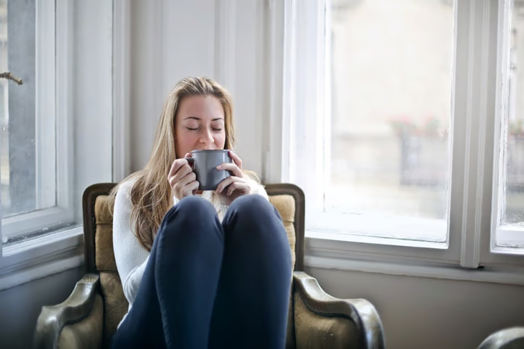 Woman drinking tea and unwinding at home