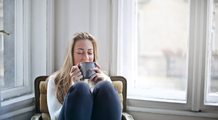 12 Simple Ways People Unwind in Today’s Hectic World Woman drinking tea and unwinding at home