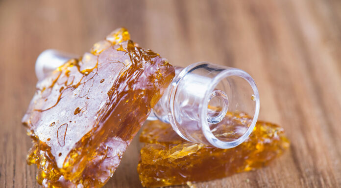 Understanding Delta 8 Concentrates: A Comprehensive Guide Piececs of cannabis oil concentrate aka shatter over wood backgr