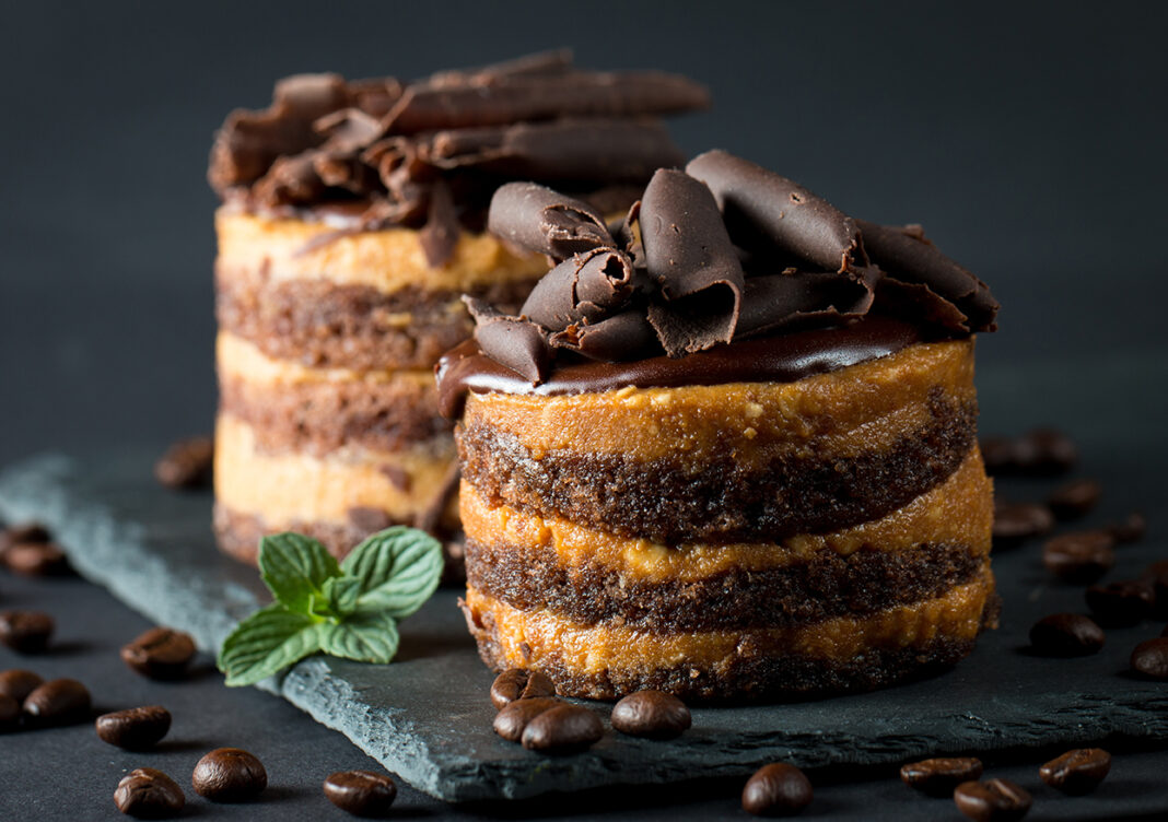 Chocolate cakes on black slatter board with mint, coffee beans o