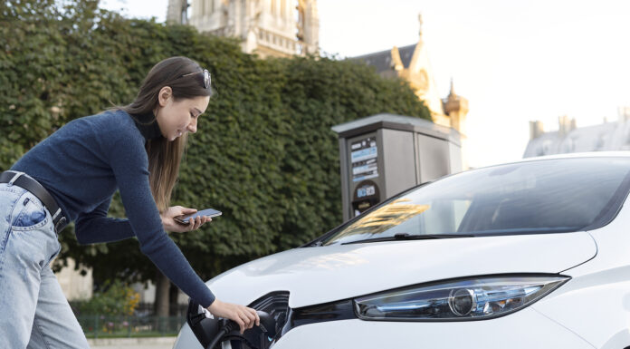 How to Prepare Your Electric Vehicle for a Multi-State Road Trip Electric Vehicle getting charged. Photo designed by Freepik