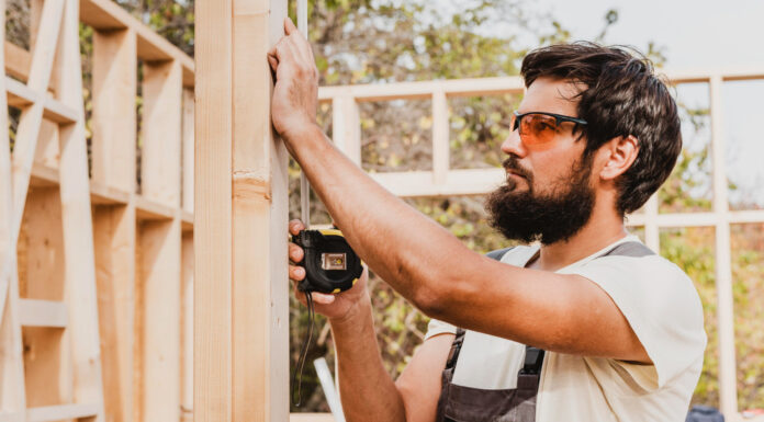 Shims 101: Everything You Need to Know for Your Next Construction Job carpenter man using a tape measure. Photo by Freepik