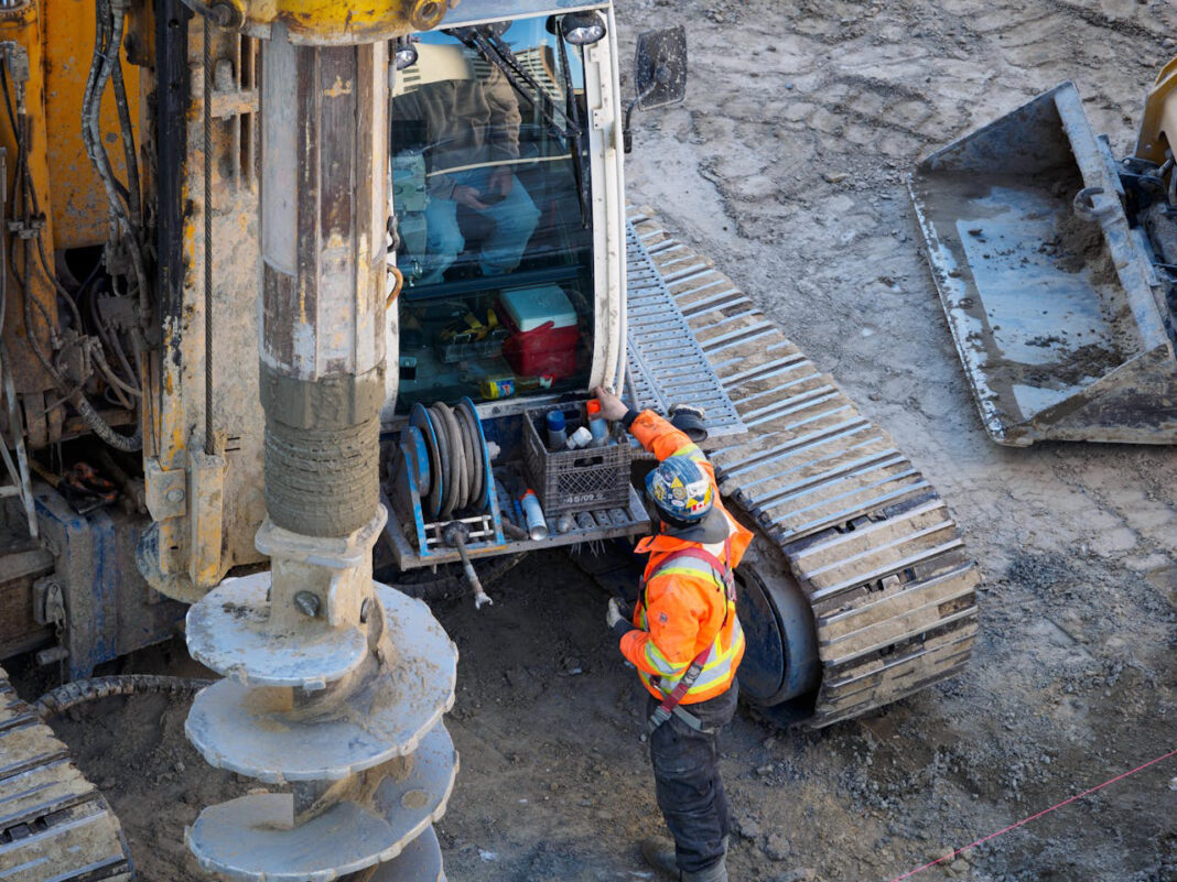 men standing next to heavy equipment at work. Photo by IslandHopper X via pexel