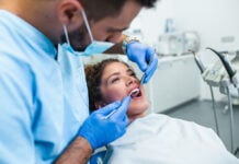A Woman is receiving dental treatment services. Photo via adobe free stock images