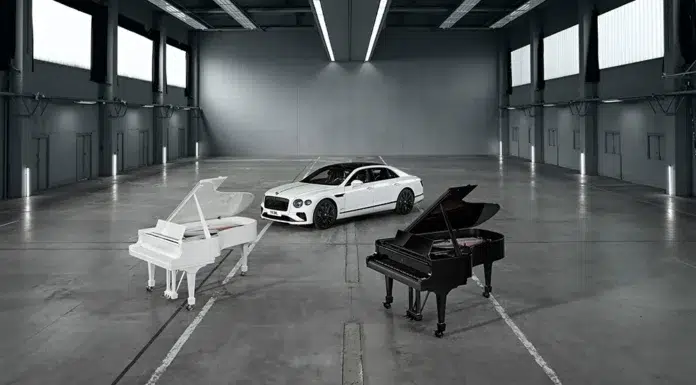 Bentley × Steinway: A Symphony of Craft and Design A Bentley Flying Spur Speed in Arctic White stands between Steinway’s Ultra Black and Ultra White grand pianos inside an industrial gallery, symbolizing the union of design, music, and motion.