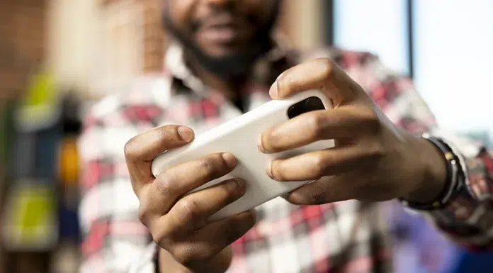 How Mobile Gaming Has Transformed Online Slot Play hands-of-male-entrepreneur-holding-cellphone-playing online gaming