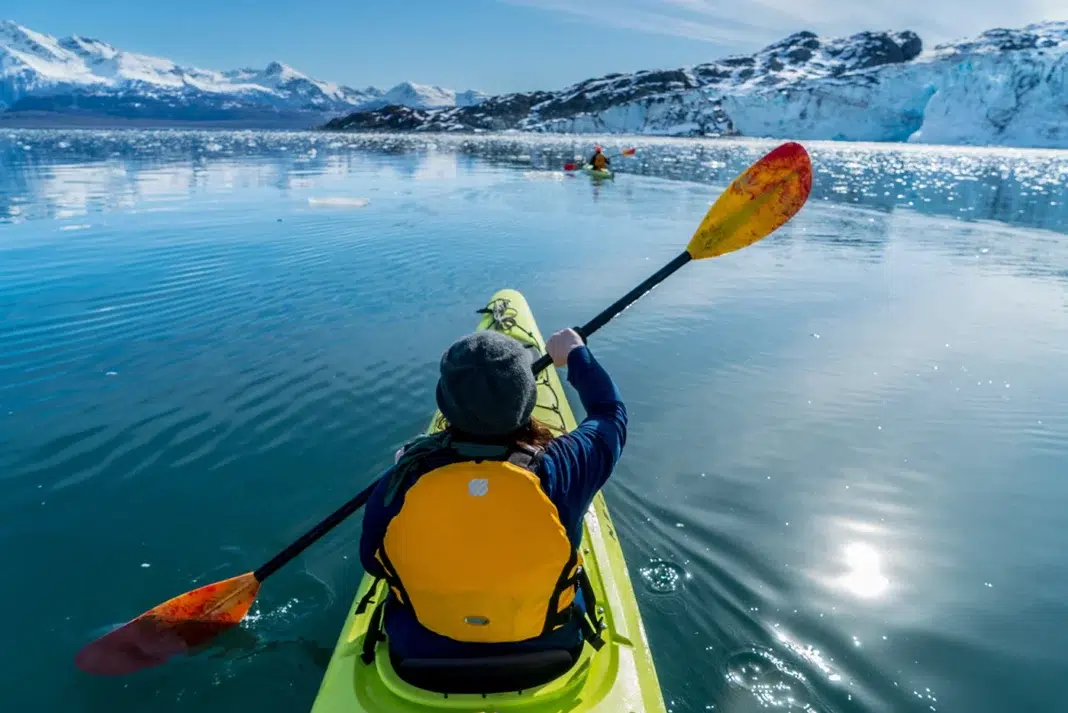 A female kayaker paddles through Glacier Bay National Park, Alaska. A female kayaker paddles through Glacier Bay National Park, Alaska.