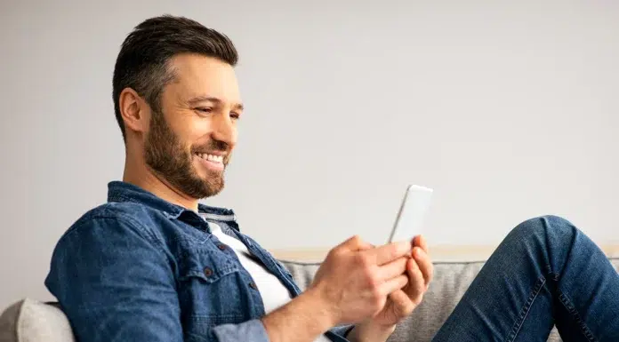 Luxury on a Budget: Why Sweepstakes Formats Appeal to High‑Taste, Low‑Risk Players Man happily playing a game while relaxing on his couch. Photo via vecteezy