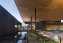Inside the Sophisticated Rebirth of Robert Mondavi Winery in Napa Valley a-modern-architectural-image-with-a-shallow-pool-and-a-patio-set-with-chairs