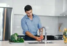 The Best Ways Houston Homeowners Can Lower Their Water Bills Men in his kitchen trying to lower his water bill. Photo by magnific