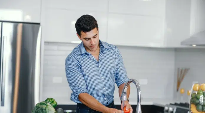The Best Ways Houston Homeowners Can Lower Their Water Bills Men in his kitchen trying to lower his water bill. Photo by magnific