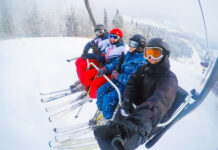Everything You Need to Know Before Your First Ski Trip Four friends skiing, friends skiing in the mountains