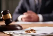 Questions to Ask Before Hiring a Divorce Lawyer Wedding rings and judge hammer on legal documents