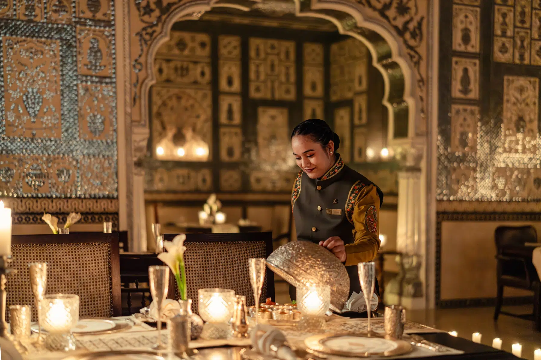 A candlelit table setting at Jamavar Jaipur captures the restaurant’s richly atmospheric approach to dining, where mirrorwork interiors and warm hospitality heighten the sense of occasion. A candlelit table setting at Jamavar Jaipur captures the restaurant’s richly atmospheric approach to dining, where mirrorwork interiors and warm hospitality heighten the sense of occasion.